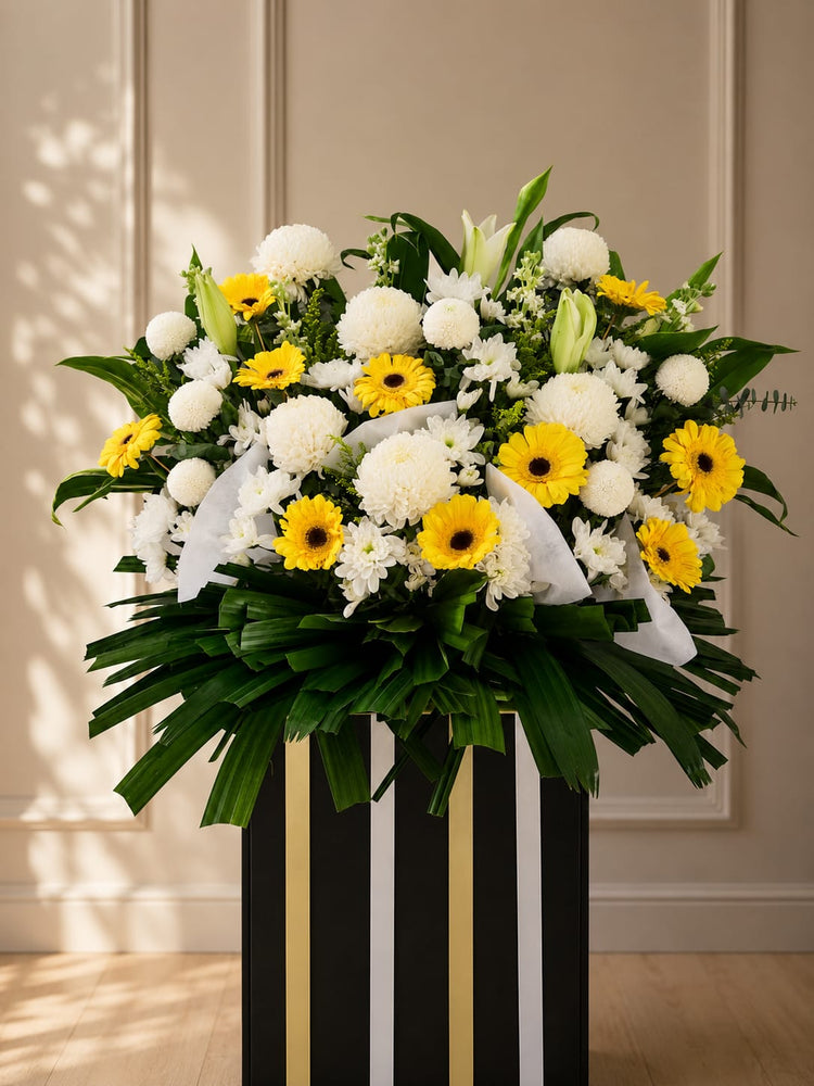 White sunflower chrysanthemum and gerbera daisies condolence standee by FlowerPlus, featuring yellow and white floral arrangements.